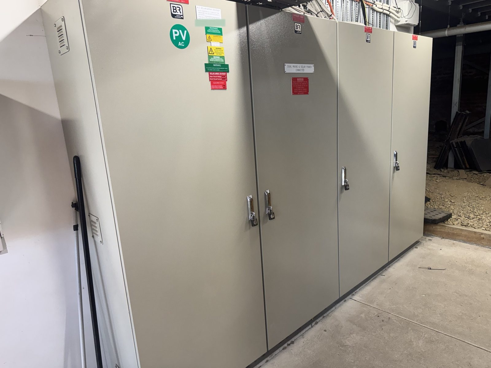 Four-door main switchboard in a switch room, doors closed and labelled